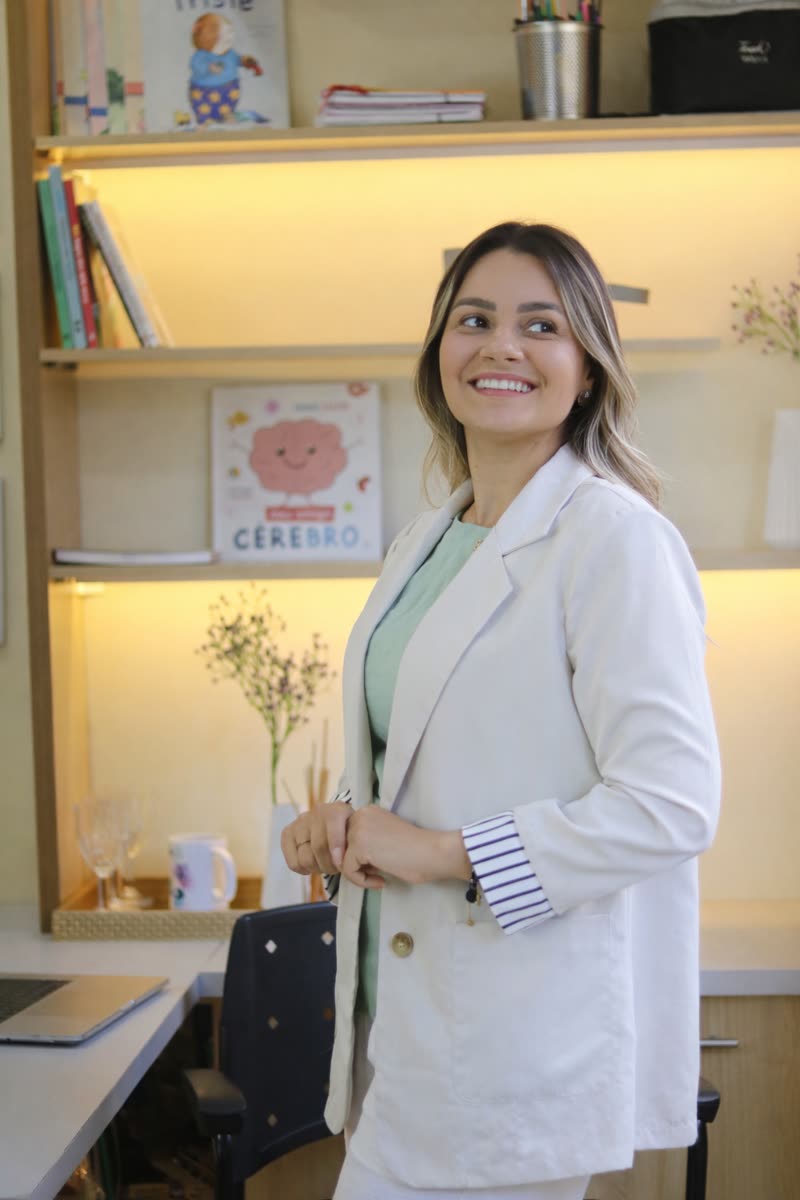 Katia Fernanda Viana de pé no consultório, sorrindo